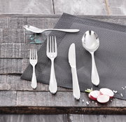 Besteckset bestehend aus Messer, Gabel, Löffel und Teelöffel auf einem grauen Platzdeckchen, von oben fotografiert.