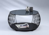 Moderner Couchtisch mit rundem Glasplatte und schwarzem Metallgestell, seitliche Perspektive.