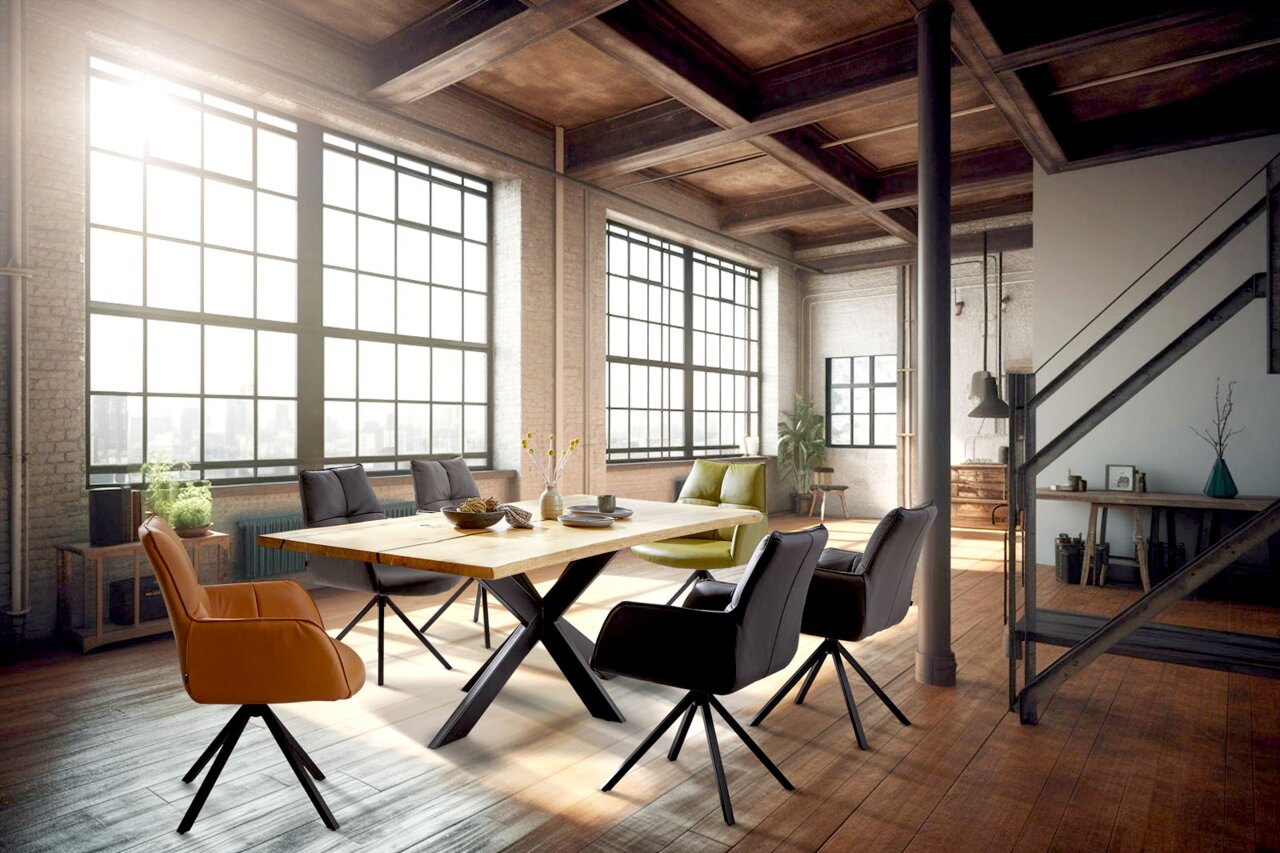 Moderner Esstisch mit X-förmigen Beinen und sechs gepolsterten Armlehnstühlen in einem loftartigen Raum mit großen Fenstern, aus der Perspektive von schräg vorne.