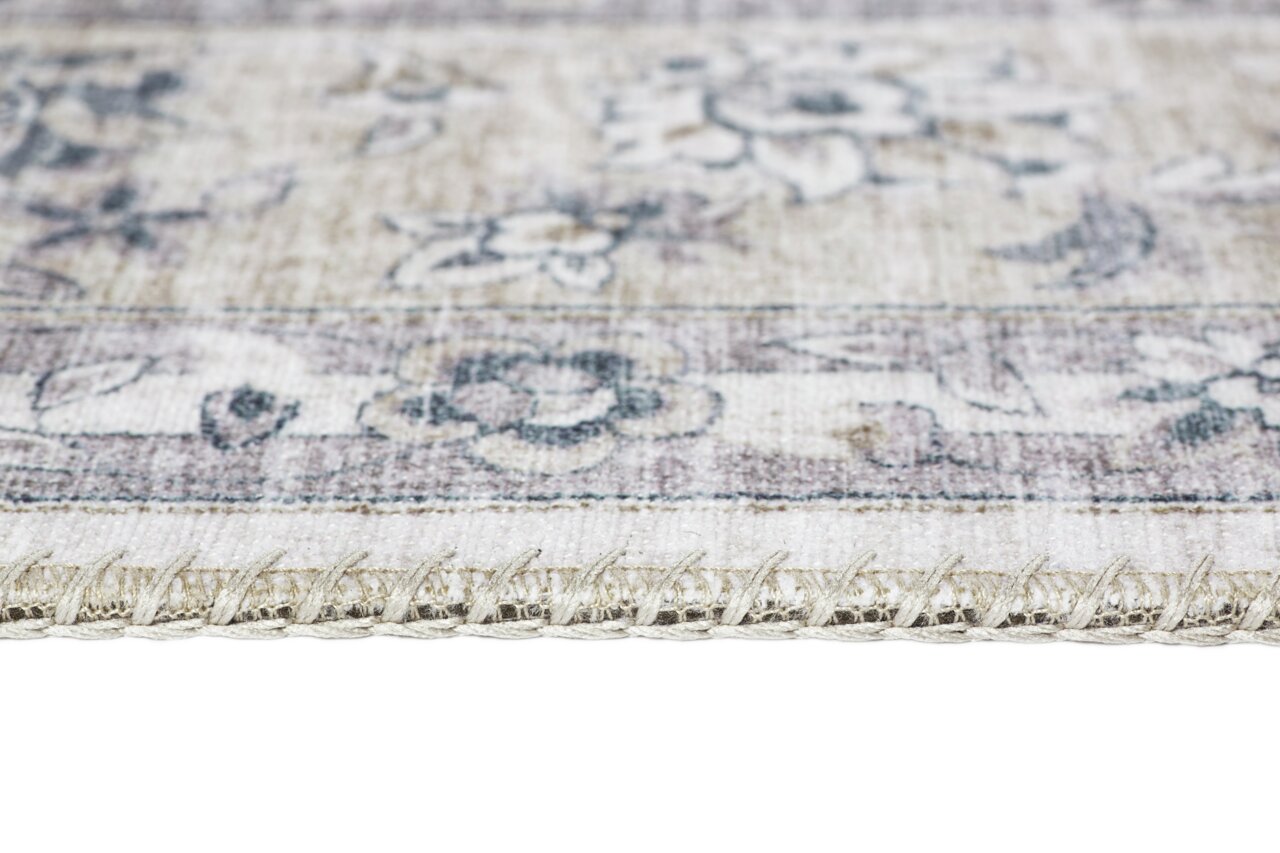 Nahaufnahme eines Teppichs mit floralen Mustern und sichtbarer Kante, seitliche Perspektive