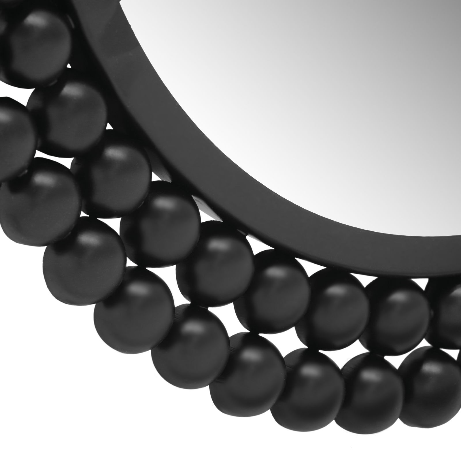 Nahaufnahme eines runden Spiegels mit einem dekorativen schwarzen Rahmen aus kugelförmigen Elementen, perspektivisch von der Seite aufgenommen.