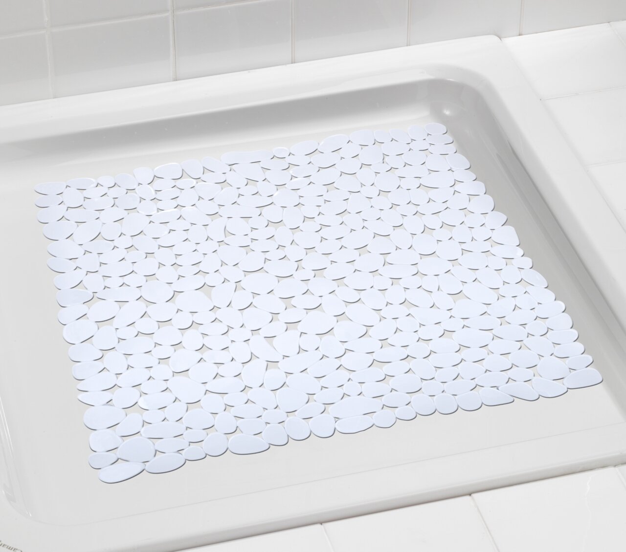 Duscheinlage Paradise White in einer Duschwanne von oben betrachtet, mit einem Muster aus weißen, steinähnlichen Formen.