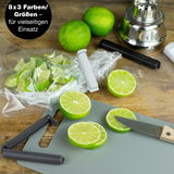 Verschlussclips in verschiedenen Farben auf einem Tisch mit Limetten und einem Schneidebrett, von oben fotografiert