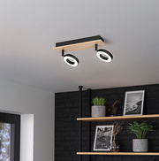 Moderne Deckenleuchte mit zwei runden, verstellbaren Spots auf einer Holz- und Metallhalterung, von unten betrachtet.