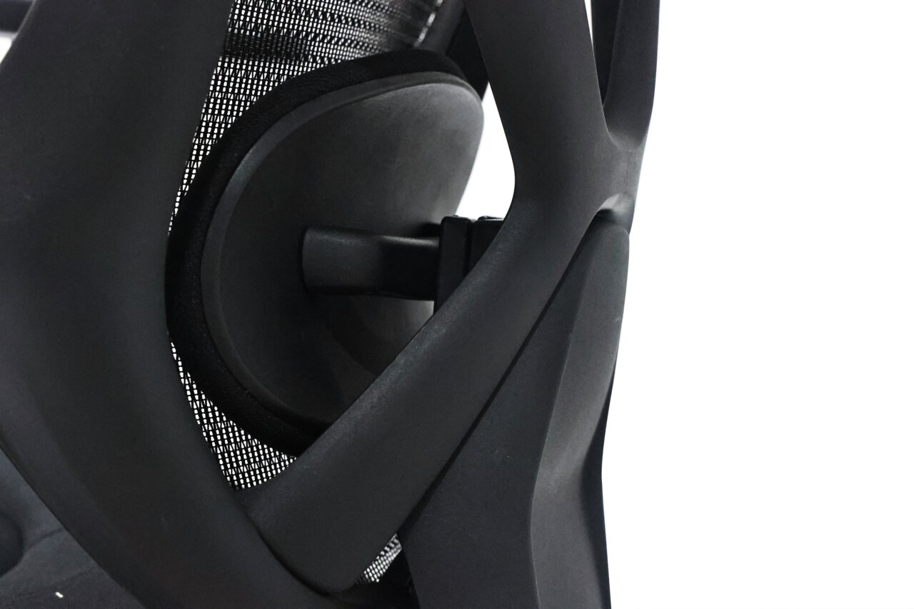 Nahaufnahme der Rückenlehne eines Drehstuhls mit ergonomischem Design und Netzstruktur, seitliche Perspektive