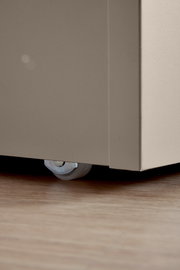 Nahaufnahme eines Bettkastens mit Rolle auf Holzboden, seitliche Perspektive