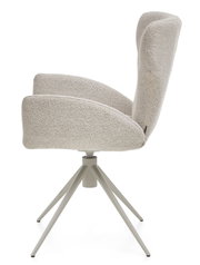 Zijaanzicht van een moderne fauteuil met een lichtgrijze stoffen bekleding en een draaibaar metalen onderstel.