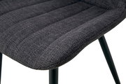 Detailaufnahme der gepolsterten Sitzfläche eines Stuhls mit dunkelgrauem Stoffbezug und schwarzen Metallbeinen, Perspektive schräg von oben