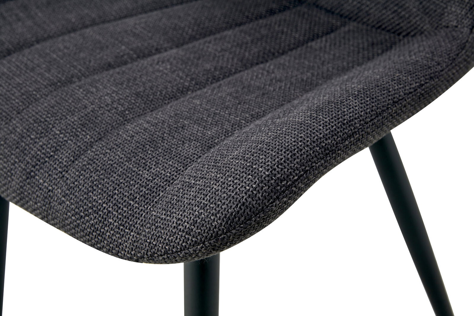 Detailaufnahme der gepolsterten Sitzfläche eines Stuhls mit dunkelgrauem Stoffbezug und schwarzen Metallbeinen, Perspektive schräg von oben