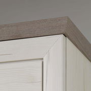 Nahaufnahme der oberen Ecke eines Sideboards aus hellem Holz mit dunklerer Holzplatte, Perspektive von unten.