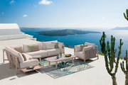 Moderne Loungeecke mit Sofa und Tisch auf einer Terrasse mit Meerblick, seitliche Perspektive