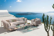 Moderne Loungeecke mit Sofa und Tisch auf einer Terrasse mit Meerblick, seitliche Perspektive