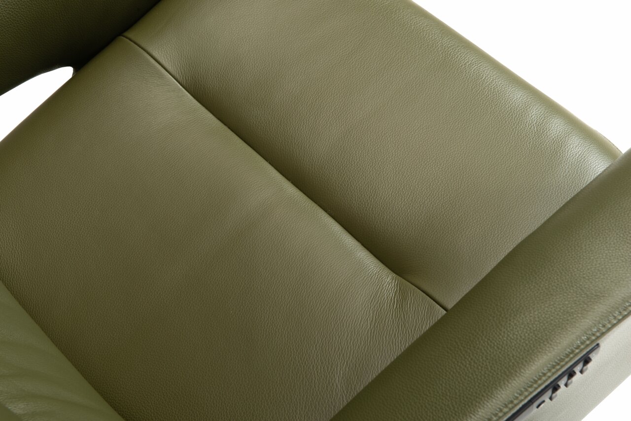 Close-up van een groene lederen relaxfauteuil, gezien van bovenaf.