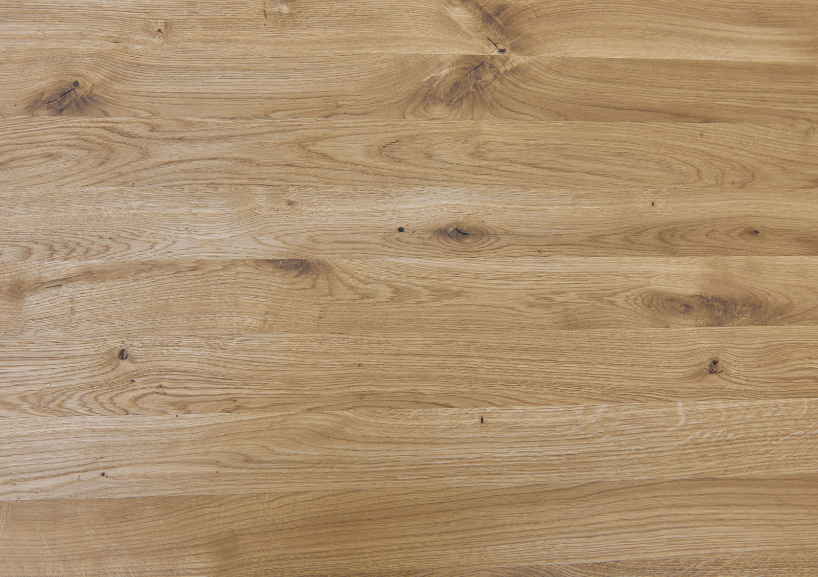 Nahaufnahme einer Holzoberfläche mit natürlicher Maserung, aus der Vogelperspektive fotografiert.