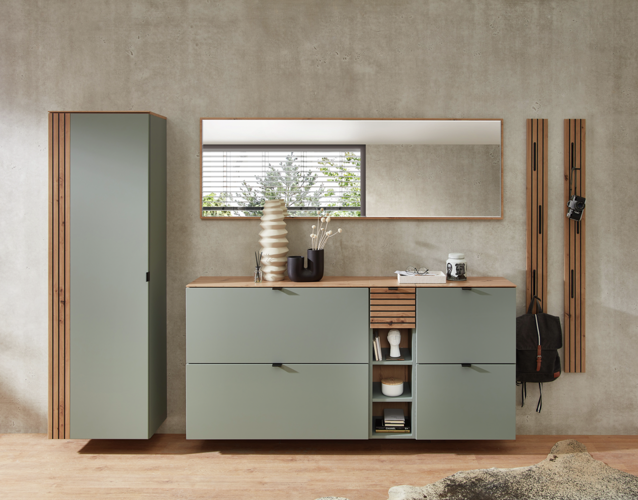 Moderne Garderobeneinrichtung in Schilfgrün mit Hängeschrank, Spiegel und Schuhschrank, frontal betrachtet.