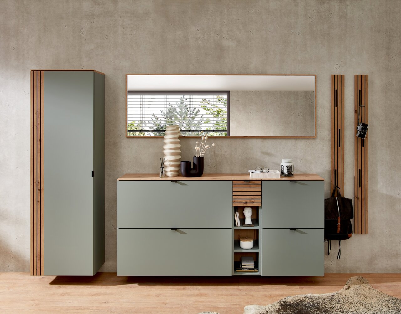 Moderne Garderobeneinrichtung in Schilfgrün mit Hängeschrank, Spiegel und Schuhschrank, frontal betrachtet.