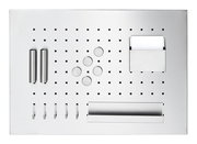 Metallisches Memoboard mit Utensilien, inklusive Haken, Magneten und Ablagefächern, aus der Vogelperspektive.
