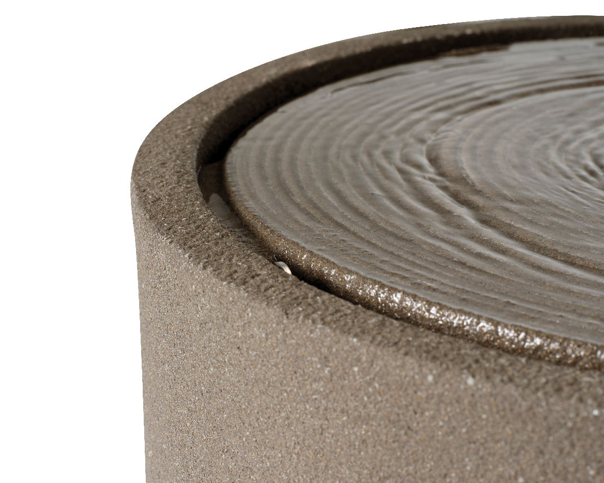 Nahaufnahme eines runden Brunnens mit fließendem Wasser auf der Oberfläche, seitliche Perspektive