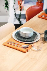 Müslischale 15 cm auf einem gedeckten Tisch, von oben fotografiert. Die Schale hat ein modernes, geometrisches Muster in Schwarz und Weiß, platziert auf passenden Tellern mit Besteck und einem Glas daneben.