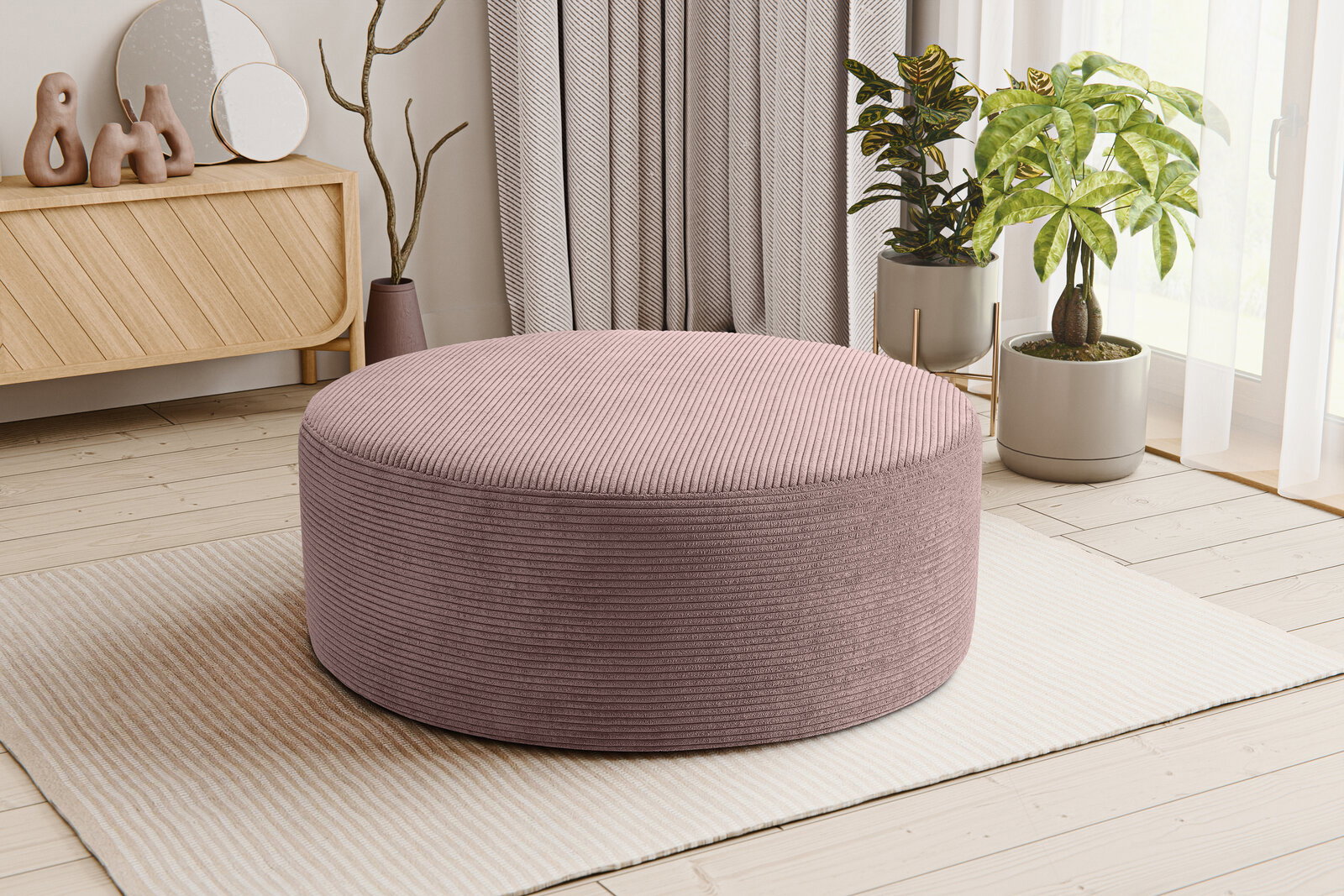 Runder, flacher Cord-Sitzpouf in Altrosa auf hellem Teppich im Wohnzimmer, perspektivisch in leichter Seitenansicht von vorne