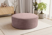 Runder, flacher Cord-Sitzpouf in Altrosa auf hellem Teppich im Wohnzimmer, perspektivisch in leichter Seitenansicht von vorne