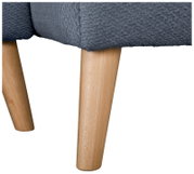 Detailaufnahme aus seitlicher Perspektive: grauer, strukturierter Polsterstoff eines Sessels/Sofas mit zwei konischen Holzbeinen auf weißem Hintergrund