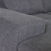 Nahaufnahme einer grauen Stoffecke eines Ecksofas, Perspektive von der Seite