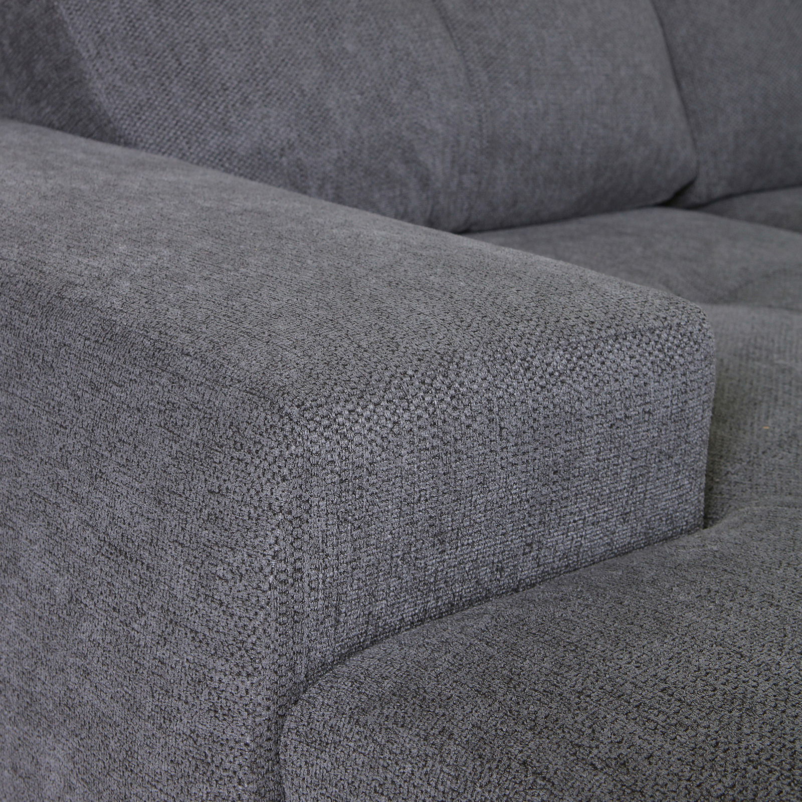 Nahaufnahme einer grauen Stoffecke eines Ecksofas, Perspektive von der Seite