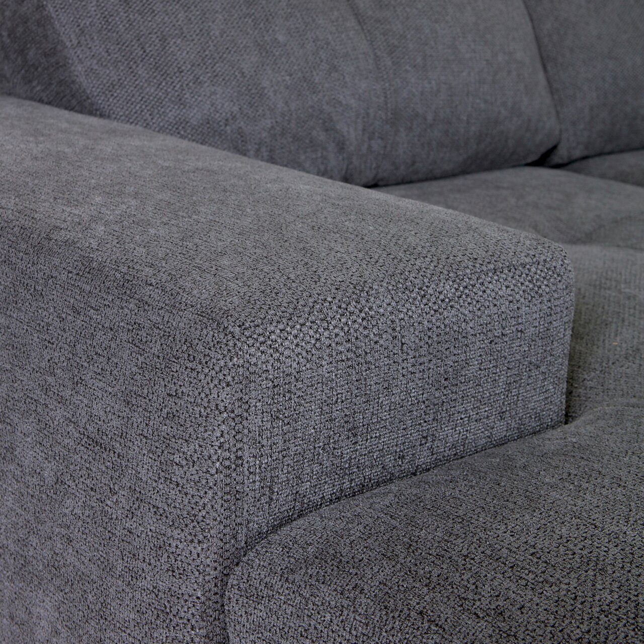 Nahaufnahme einer grauen Stoffecke eines Ecksofas, Perspektive von der Seite