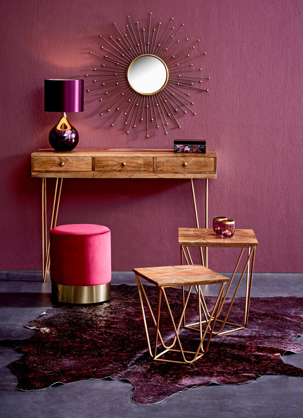 Konsolentisch aus Holz mit goldenen Beinen, dekoriert mit einer violetten Lampe und einem runden Spiegel an der Wand, aus der Frontalperspektive.