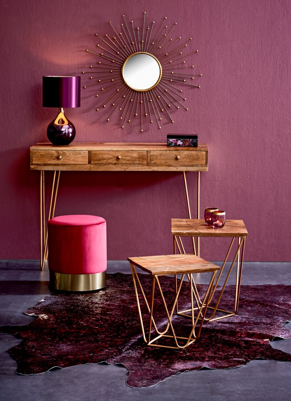 Konsolentisch aus Holz mit goldenen Beinen, dekoriert mit einer violetten Lampe und einem runden Spiegel an der Wand, aus der Frontalperspektive.