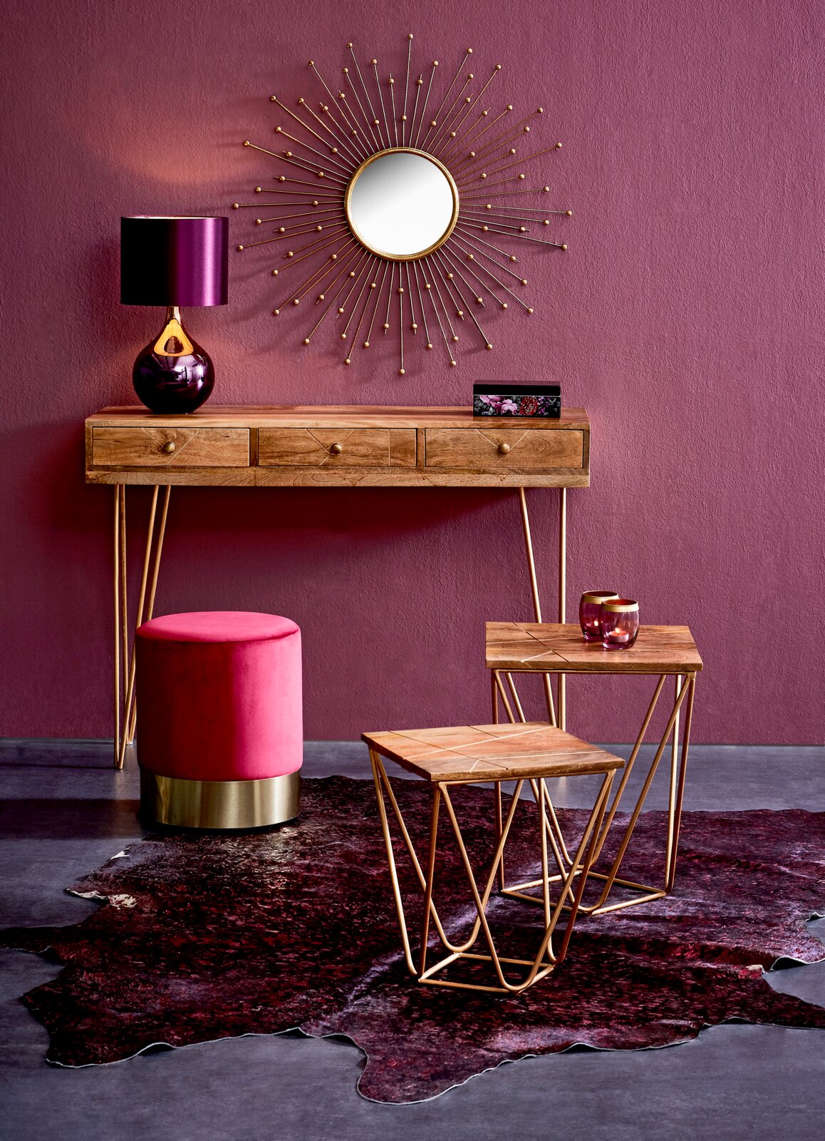 Konsolentisch aus Holz mit goldenen Beinen, dekoriert mit einer violetten Lampe und einem runden Spiegel an der Wand, aus der Frontalperspektive.
