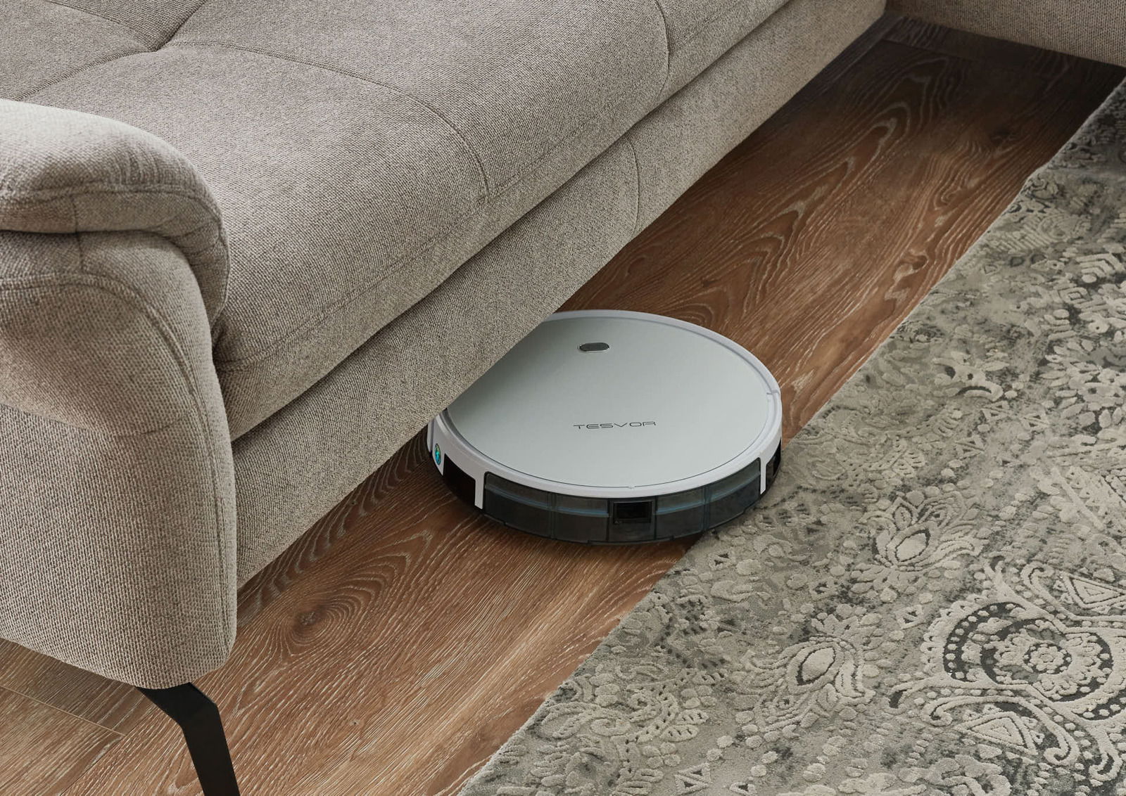 Saugroboter unter einem Sofa auf Holzboden, seitliche Perspektive