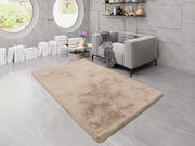 Beiger Fellteppich in einem modernen Wohnzimmer mit grauem Sofa und runden Fenstern, aus der Vogelperspektive betrachtet.