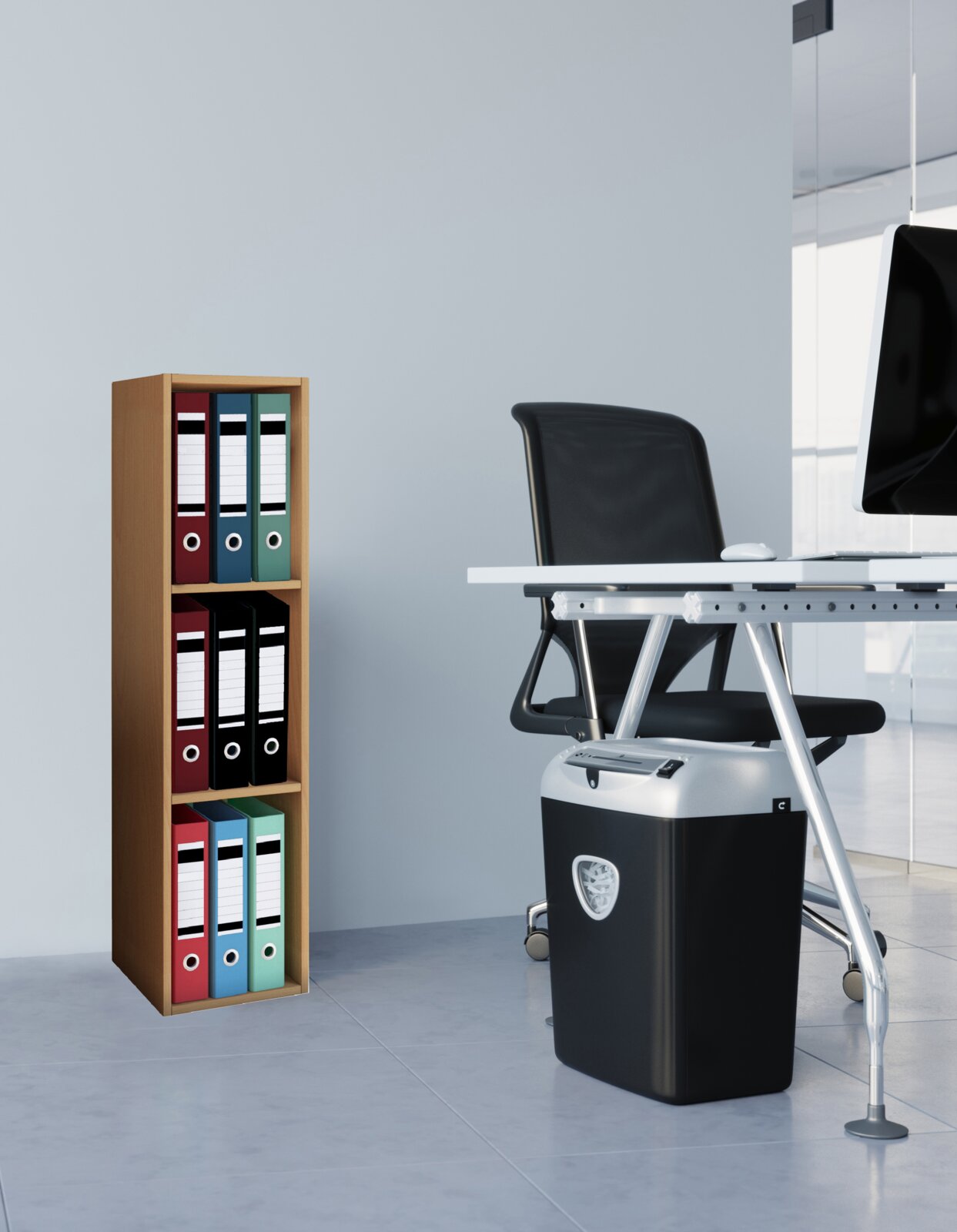 Schwarzer Aktenvernichter unter einem weißen Büroschreibtisch neben einem Holzregal mit farbigen Ordnern, aufgenommen aus seitlicher Perspektive auf Augenhöhe.
