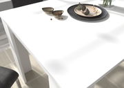 Moderner weißer Esstisch aus der Vogelperspektive mit dekorativen Schalen und Tellern.