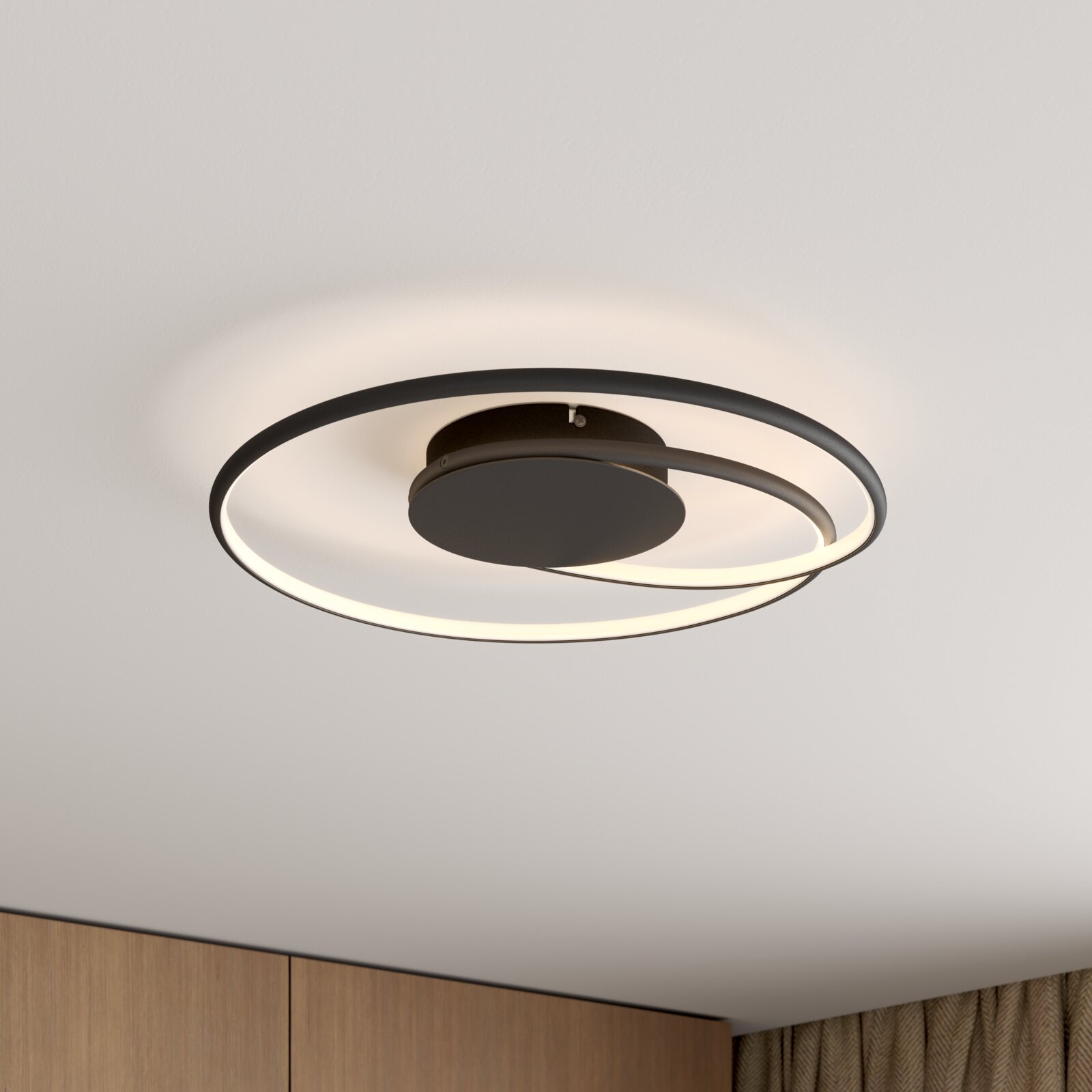 Moderne runde LED-Deckenleuchte in Schwarz mit ringförmigem Lichtband, von schräg unten an der Decke fotografiert