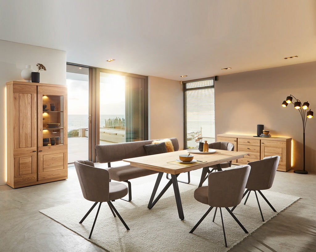 Moderner Esstisch in einem stilvollen Esszimmer mit Holz- und Metallakzenten, seitliche Perspektive.