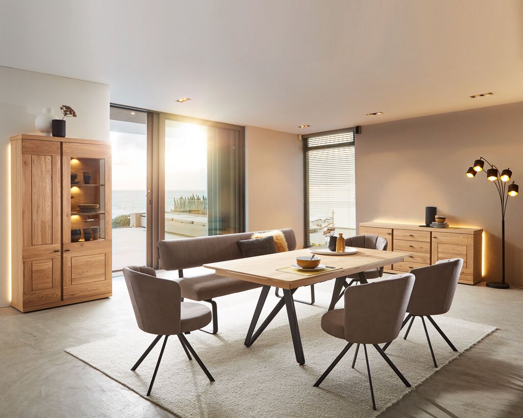 Moderner Esstisch in einem stilvollen Esszimmer mit Holz- und Metallakzenten, seitliche Perspektive.