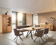 Moderner Esstisch in einem stilvollen Esszimmer mit Holz- und Metallakzenten, seitliche Perspektive.