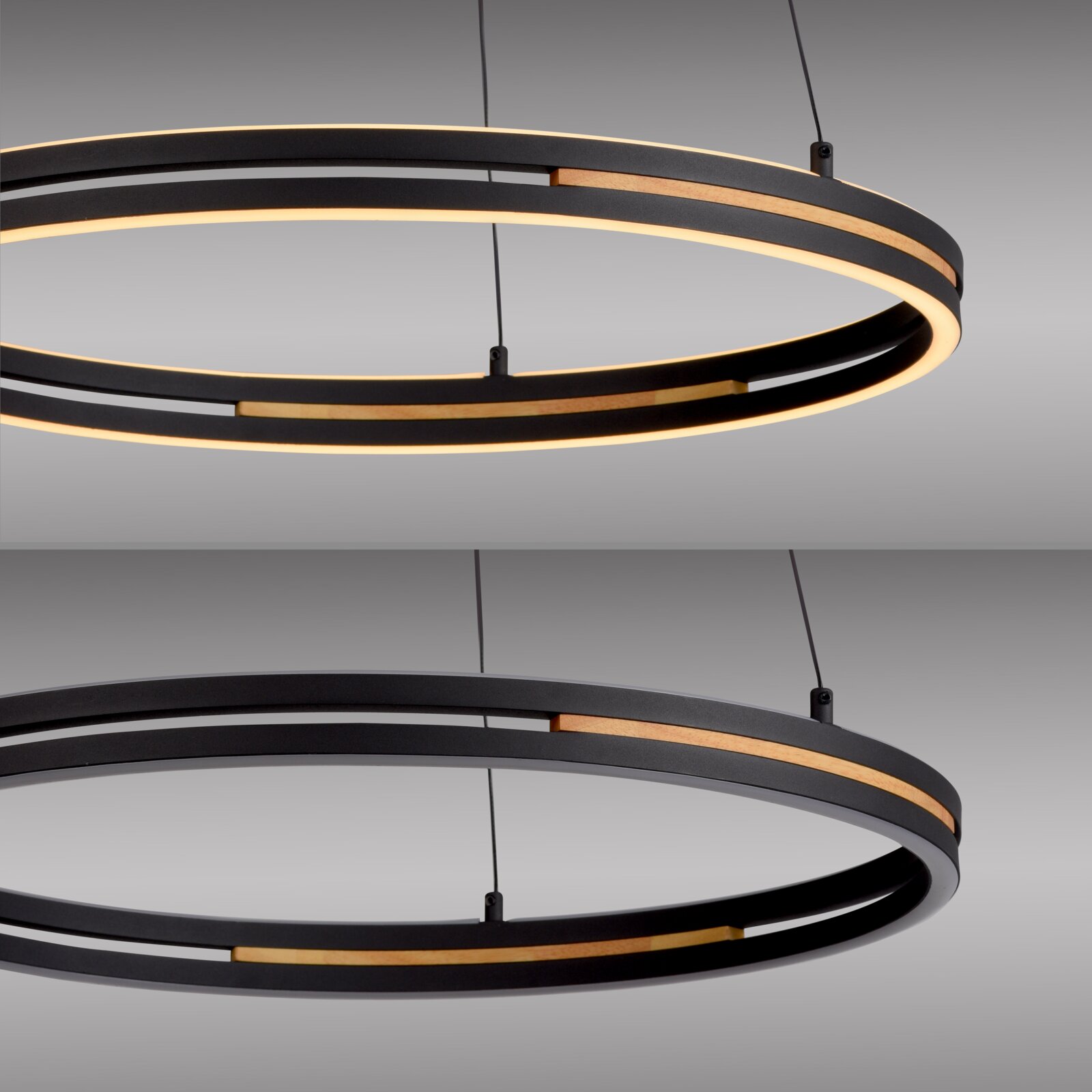 Moderne ringförmige LED-Pendelleuchte in Schwarz mit warmweißem Licht und Holz-Akzenten, an Seilen aufgehängt, Detailansicht in leicht schräger Seitenperspektive von unten