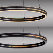 Moderne ringförmige LED-Pendelleuchte in Schwarz mit warmweißem Licht und Holz-Akzenten, an Seilen aufgehängt, Detailansicht in leicht schräger Seitenperspektive von unten