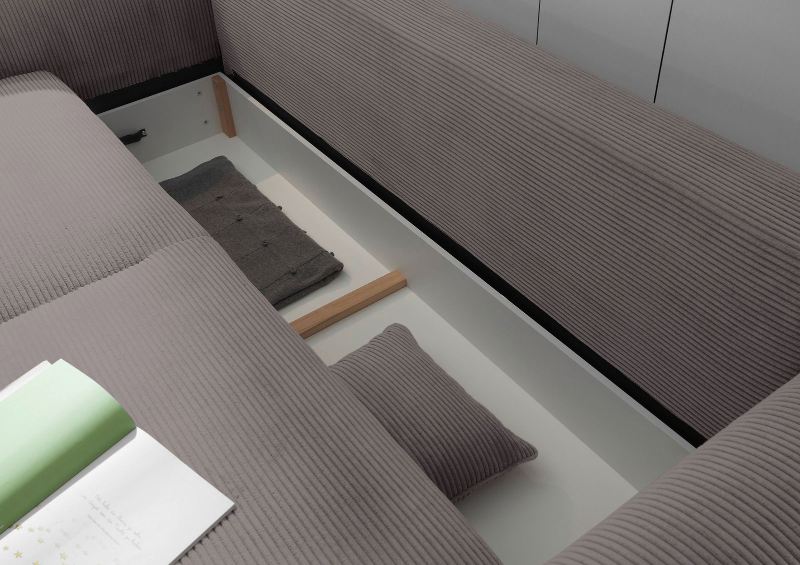 Funktionssofa mit geöffneter Stauraumfunktion, Ansicht von oben, zeigt graue Polsterung und Kissen.