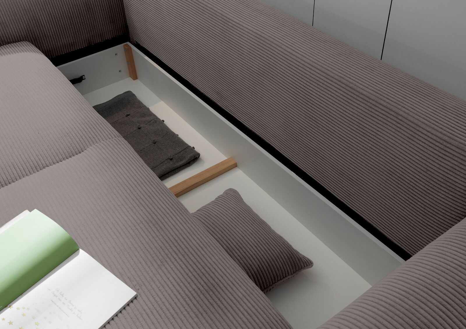 Funktionssofa mit geöffneter Stauraumfunktion, Ansicht von oben, zeigt graue Polsterung und Kissen.