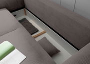Funktionssofa mit geöffneter Stauraumfunktion, Ansicht von oben, zeigt graue Polsterung und Kissen.