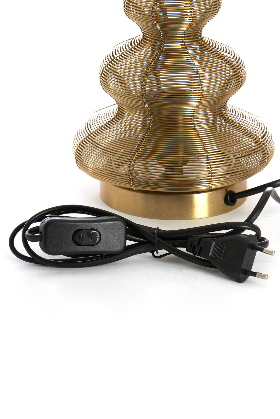 Nahaufnahme einer Tischleuchte in Form eines Weihnachtsbaums aus goldfarbenem Drahtgeflecht mit schwarzem Kabel und Schalter, seitliche Perspektive.