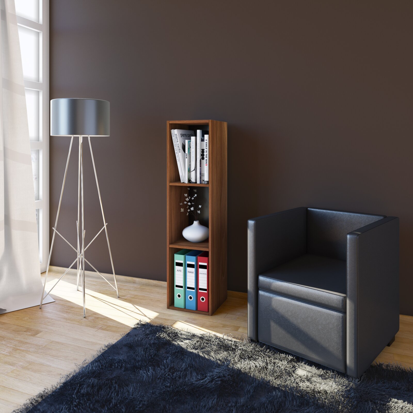 Schmales, hohes Standregal in Nussbaum-Optik mit drei Fächern, befüllt mit Büchern, Vase und Ordnern, im Wohnzimmer neben Stehlampe und schwarzem Sessel; Perspektive: leicht seitliche Frontansicht auf Augenhöhe