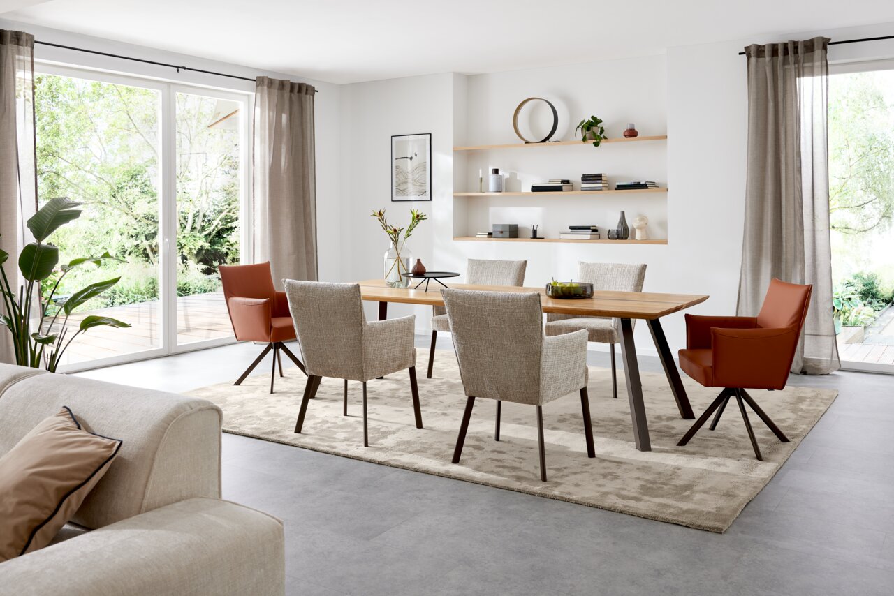 Musterring Armlehnstuhl MR NILAN Esszimmer mit modernem Esstisch und Armlehnstühlen in einem hellen Raum mit großen Fenstern, seitliche Perspektive