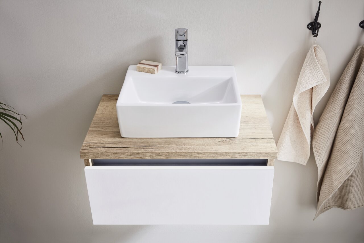 Dieter Knoll Gästebad PONTE Moderne Waschbeckenkombination mit rechteckigem, weißen Becken und Holzunterschrank, von oben betrachtet.