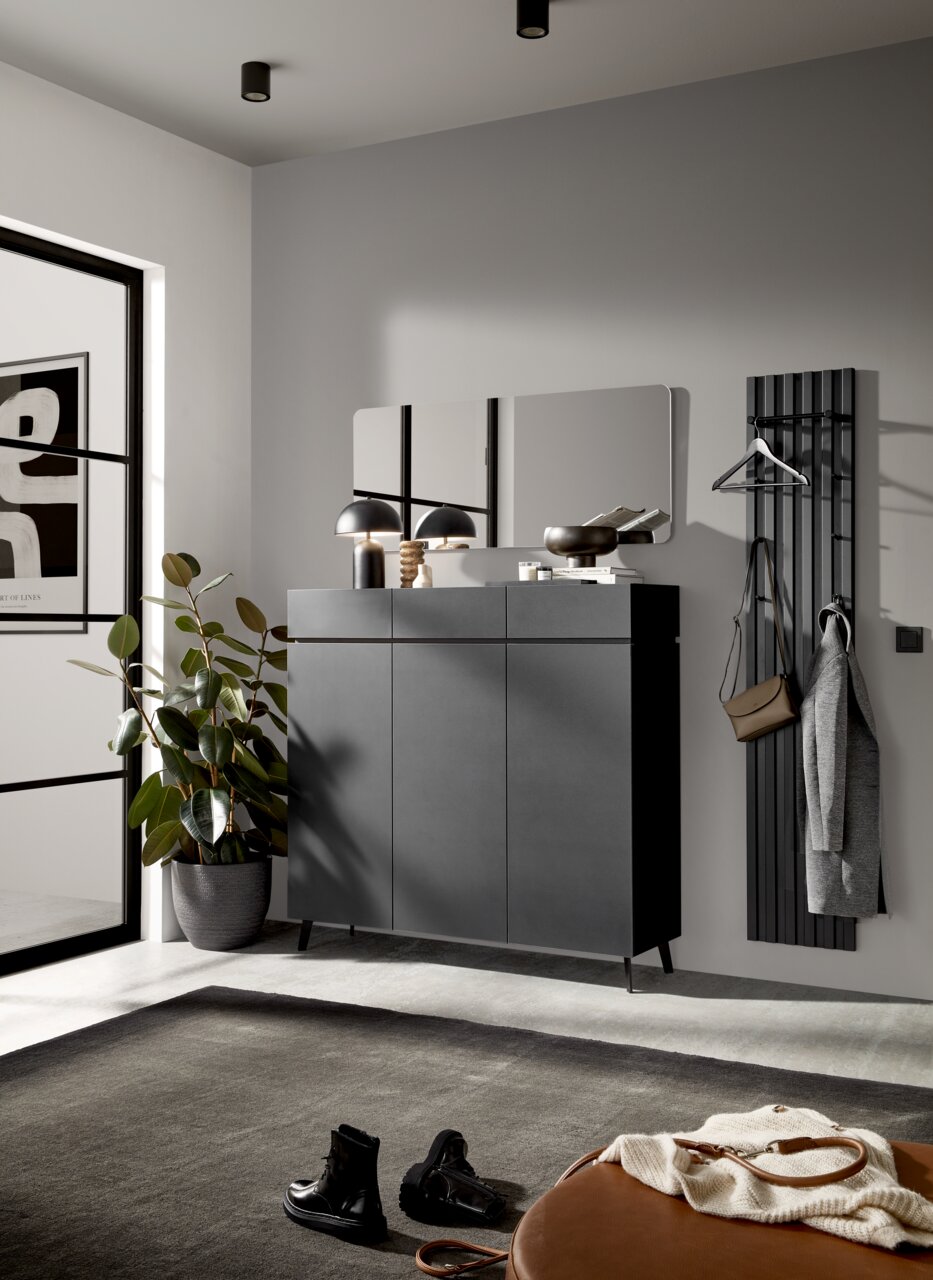 Voleo XL-Schuhschrank UNIQUE Moderner Eingangsbereich mit schwarzem Schuhschrank, Wandspiegel und Garderobenpaneel, seitliche Perspektive